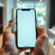 Person holding a modern smartphone in a softly blurred retail environment