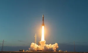 SpaceX Falcon 9 rocket launching at dawn with Starlink satellites visible in the sky