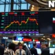 Stock market ticker board showing mixed trading ahead of Nvidia earnings