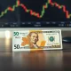 Swiss franc and US dollar banknotes side by side on a desk, symbolizing USD/CHF forex trading.
