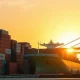 Container ship and cranes at the Port of Kaohsiung, Taiwan, symbolizing surging AI-driven exports.