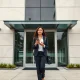 Person walking into a modern office building in Culver City, representing TikTok's corporate headquarters during the privacy settlement.