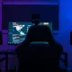 Twitch streamer setup with monitor and webcam in a dimly lit room, representing AI training on user content.