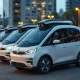 A fleet of autonomous electric robotaxis parked in a modern urban setting at dusk