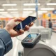Shopper using a smartphone for contactless payment at a Walmart checkout