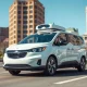Waymo Ojai robotaxi driving on a sunny San Francisco street