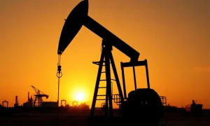 Oil pump jack silhouetted against a sunset, representing WTI crude oil price movements.