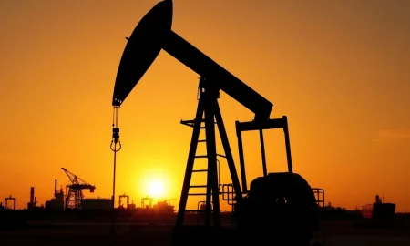 Oil pump jack silhouetted against a sunset, representing WTI crude oil price movements.