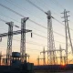 Electrical substation with transmission towers and solar panels at dusk, representing Xcel Energy's infrastructure investments