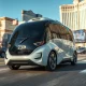 Autonomous robotaxi driving on a Las Vegas street with the Strip in the background