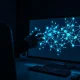 A human hand reaching toward a computer monitor displaying a glowing neural network, representing AI risk.