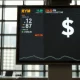 Digital currency exchange board showing Yen and US Dollar symbols in a Tokyo financial district.