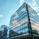 Exterior view of a modern glass office building representing Google's headquarters in a story about its antitrust case.