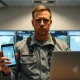 U.S. military service member holding smartphone and laptop with privacy settings visible