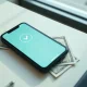 Smartphone showing X Money payment confirmation interface with cash on a desk
